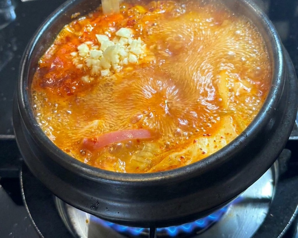 Frisch gehackter Knoblauch wird in die Mitte der kochenden Suppe gegeben.