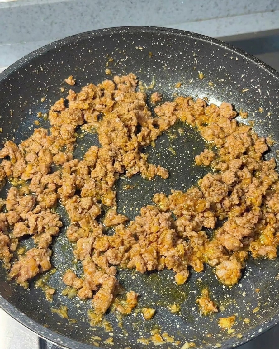 Hackfleisch wird in der Pfanne angebraten, bis es eine braune und krümelige Textur hat.