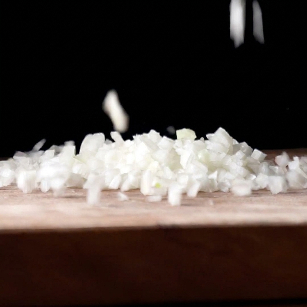 Fein gewürfelte weiße Zwiebelstücke fallen auf ein hölzernes Schneidebrett vor dunklem Hintergrund.