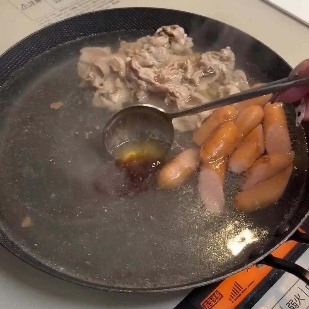 Gochujang und Misopaste lösen sich in der kochenden Brühe auf.