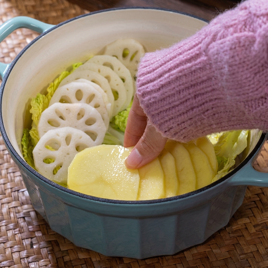 Eine bunte Anordnung aus Kartoffelscheiben und verschiedenen Pilzen im Kochtopf.