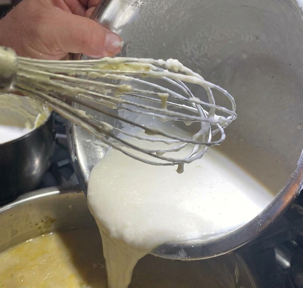 Weißer Pfeffer wird über die Suppenbasis gestreut.