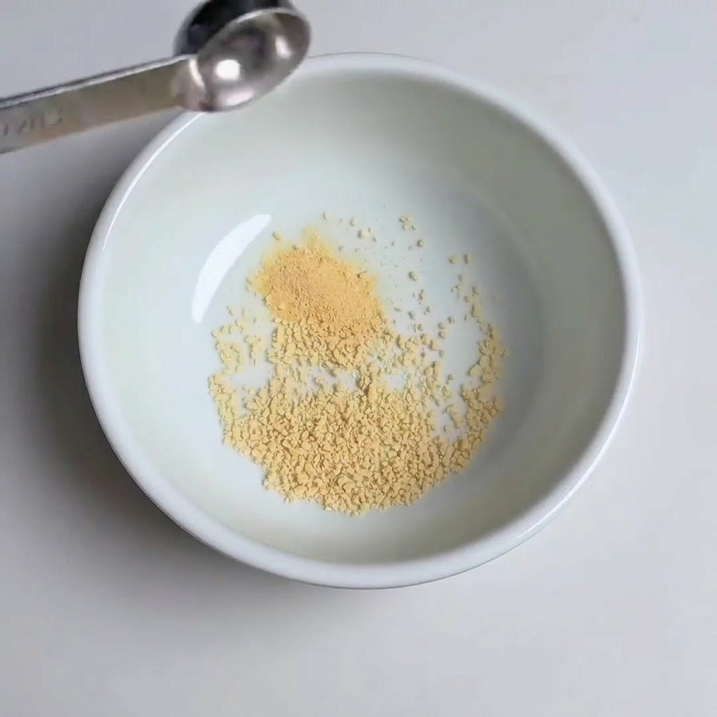Messlöffel geben Knoblauchpulver, Zucker und Gochujang-Paste in die Schüssel.