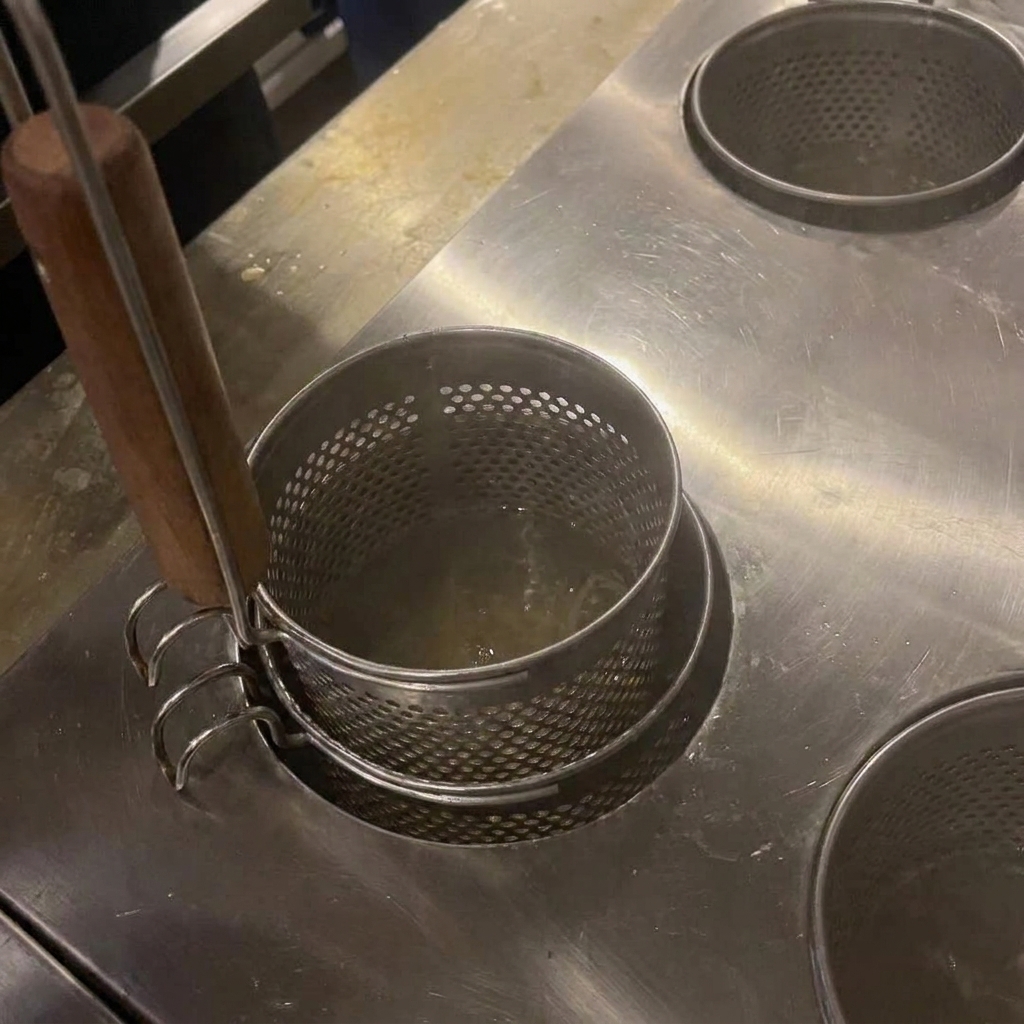 Nudeln werden mit Holzstäbchen in kochendem Wasser umgerührt.