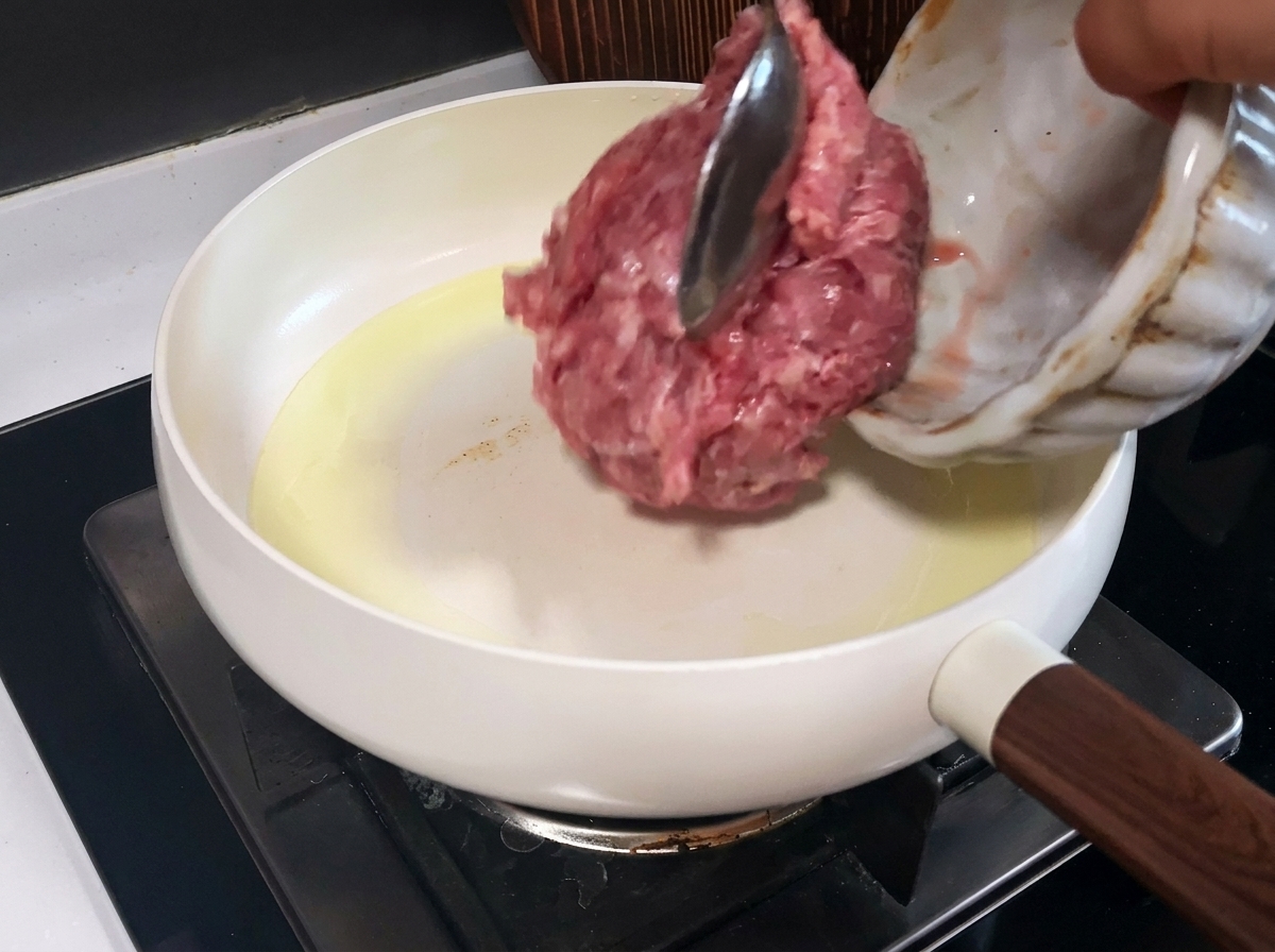 In einer Pfanne angebratenes, braunes Schweinehackfleisch.
