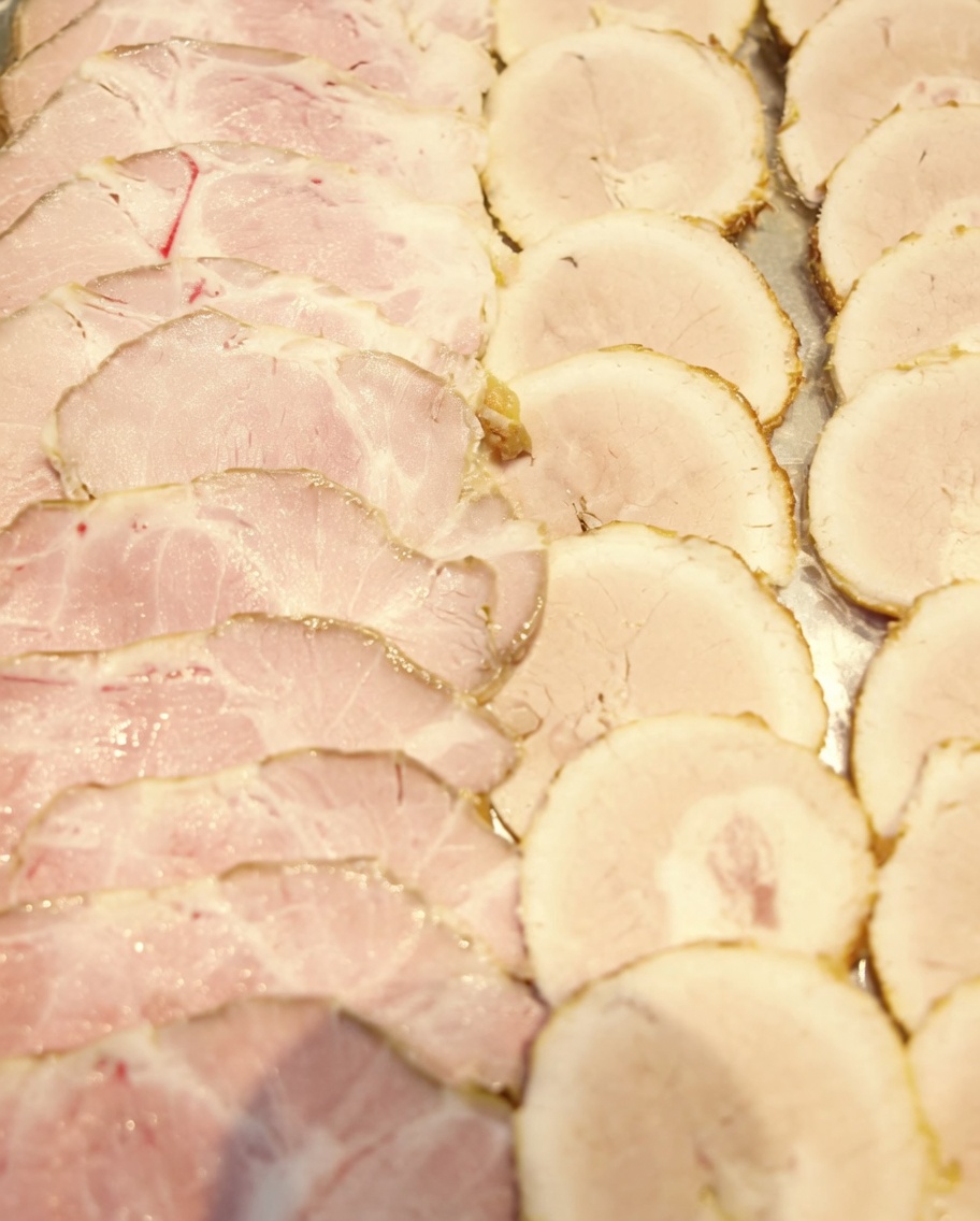 Dünn aufgeschnittene Chashu-Scheiben liegen auf einem Tablett bereit zum Servieren.