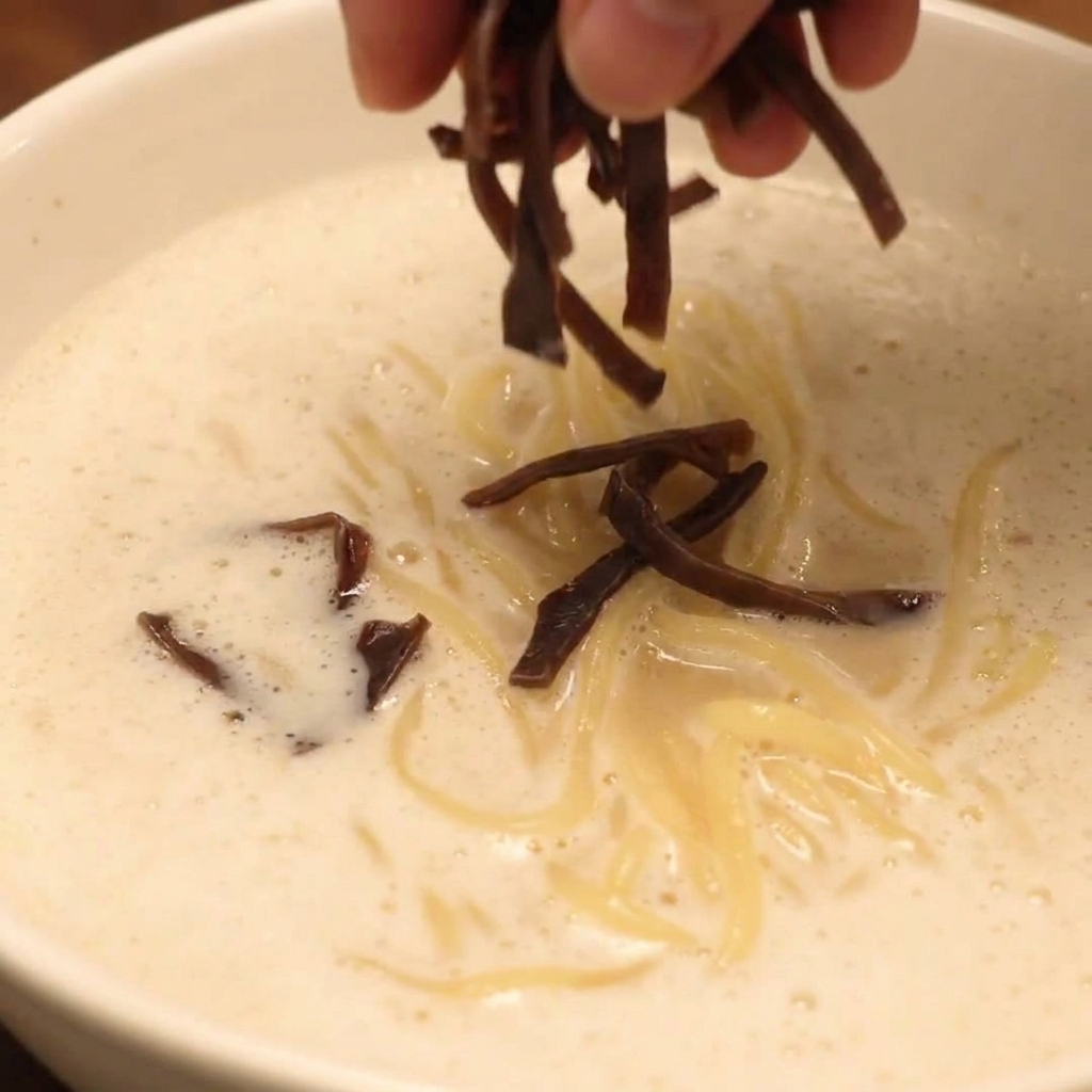 Eine fertig angerichtete Schüssel Chicken Paitan Foam Ramen mit Toppings.