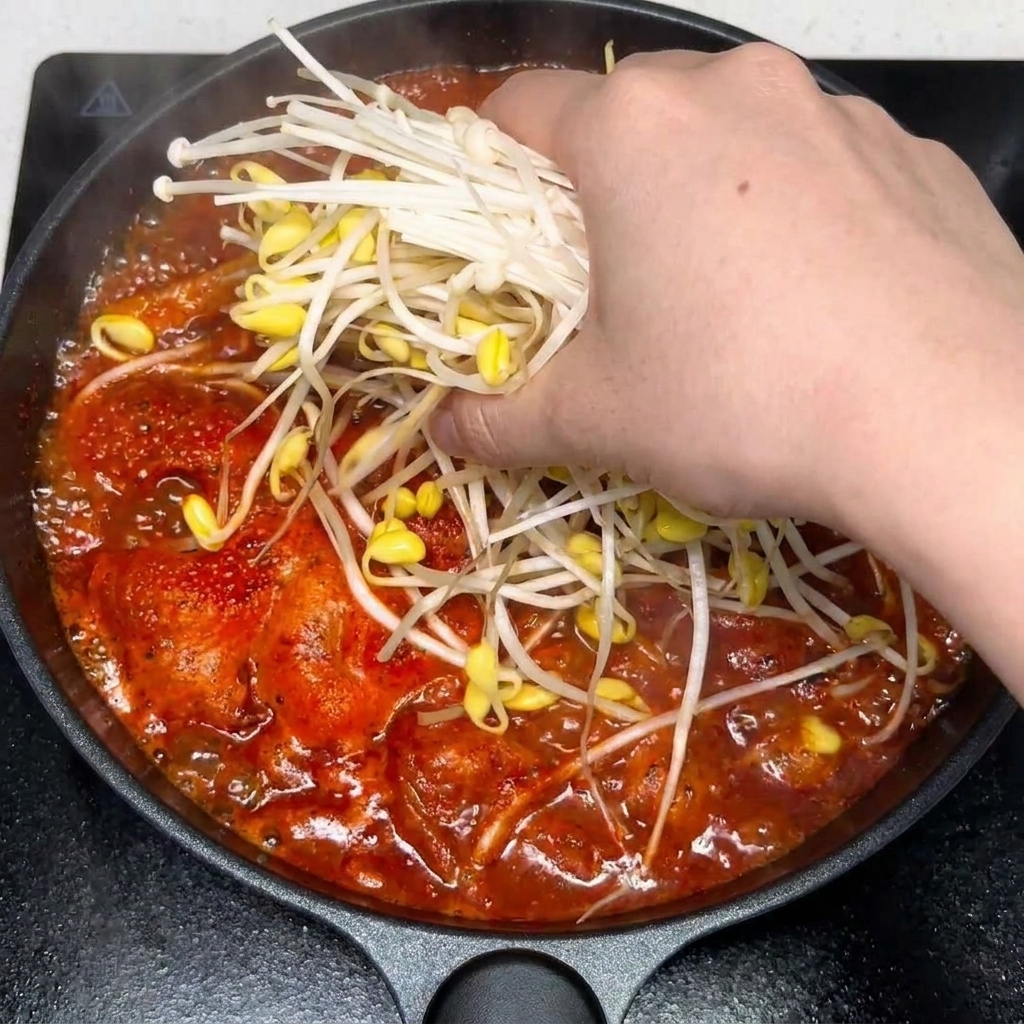Knoblauch und Gewürze werden in die Suppe eingerührt.