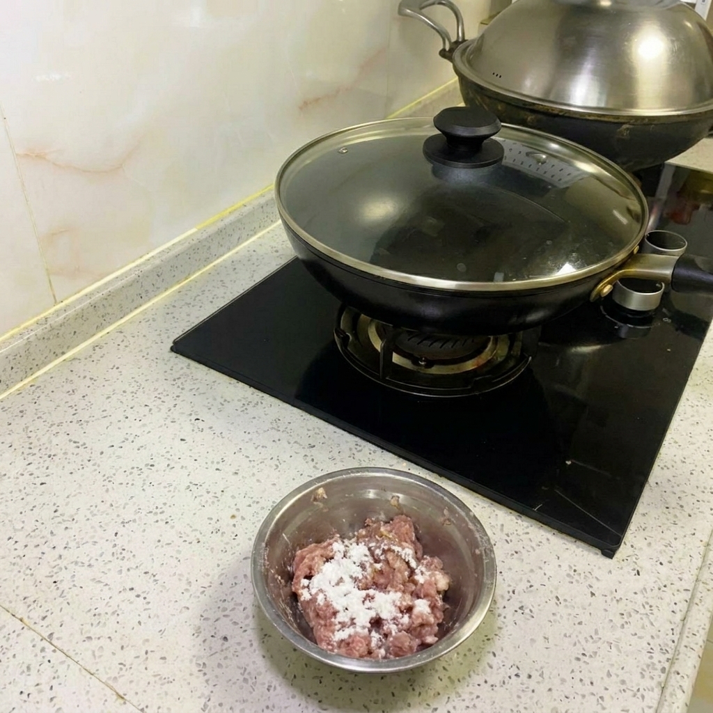 Hackfleisch wird mit Essstäbchen aus Metall kräftig gerührt, bis es klebrig ist.