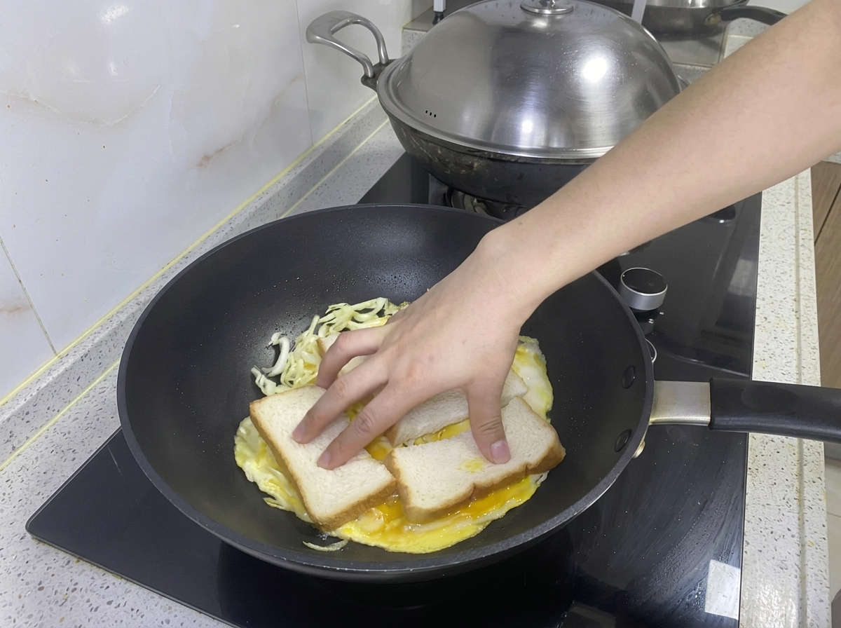Zwei Scheiben Brot werden auf das Ei-Kohl-Omelett in der Pfanne gelegt.