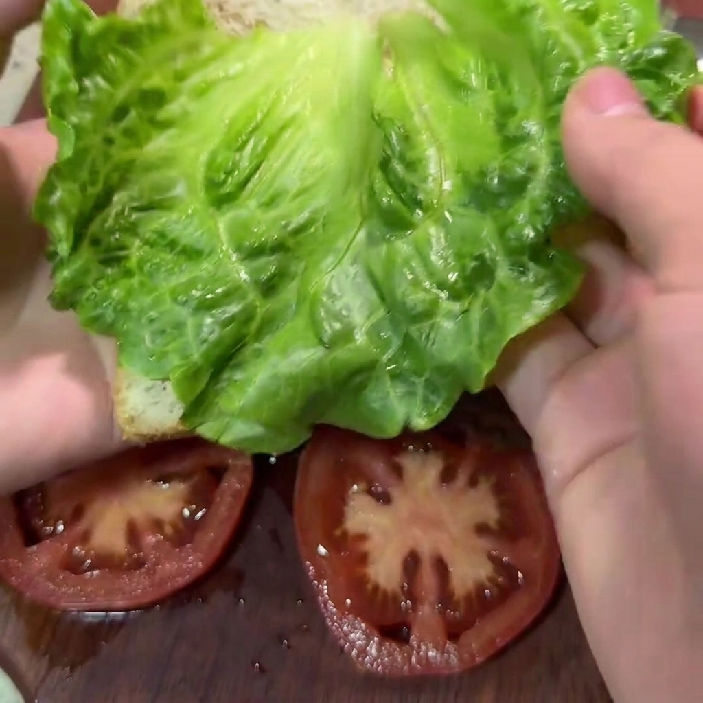 Ein Holzlöffel vermengt das Rinderhackfleisch mit Gemüse und Gewürzen in einer großen weißen Schüssel.
