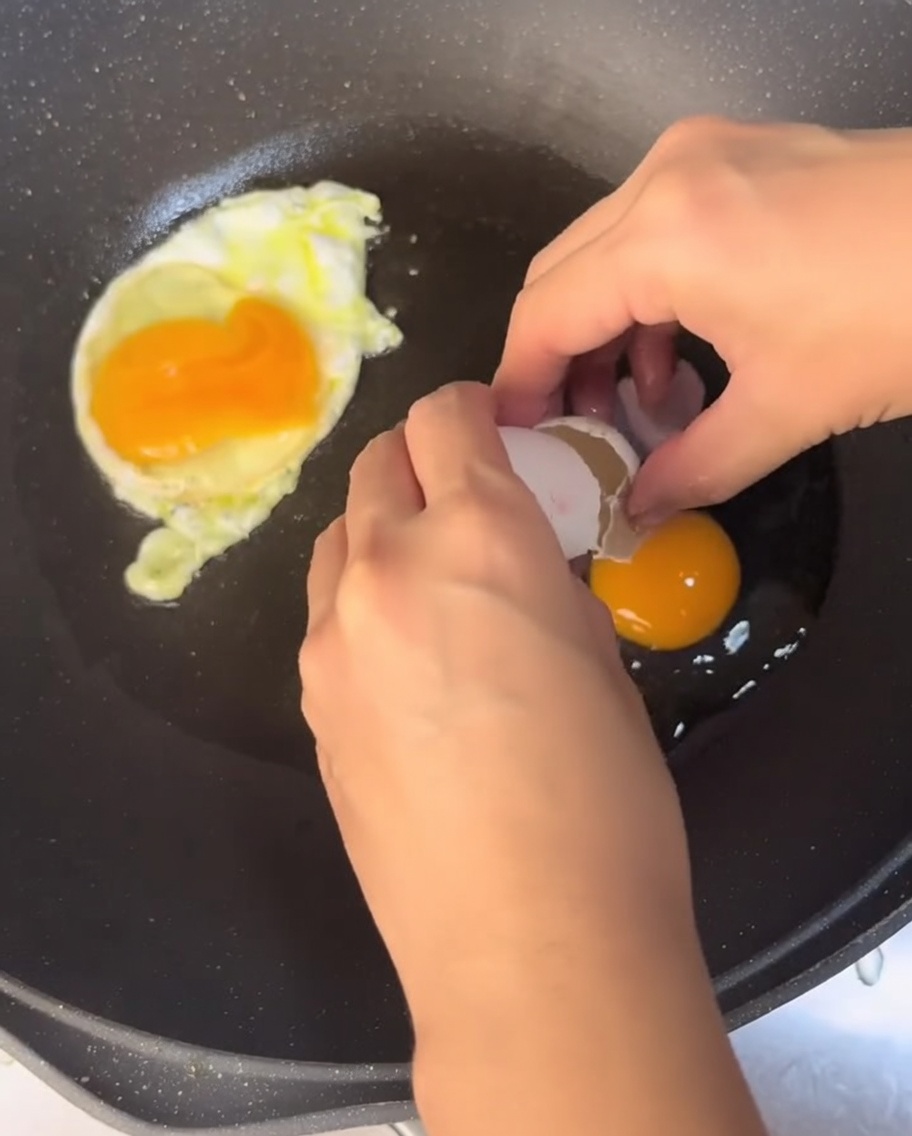Eier braten in einer Pfanne mit heißem Öl.