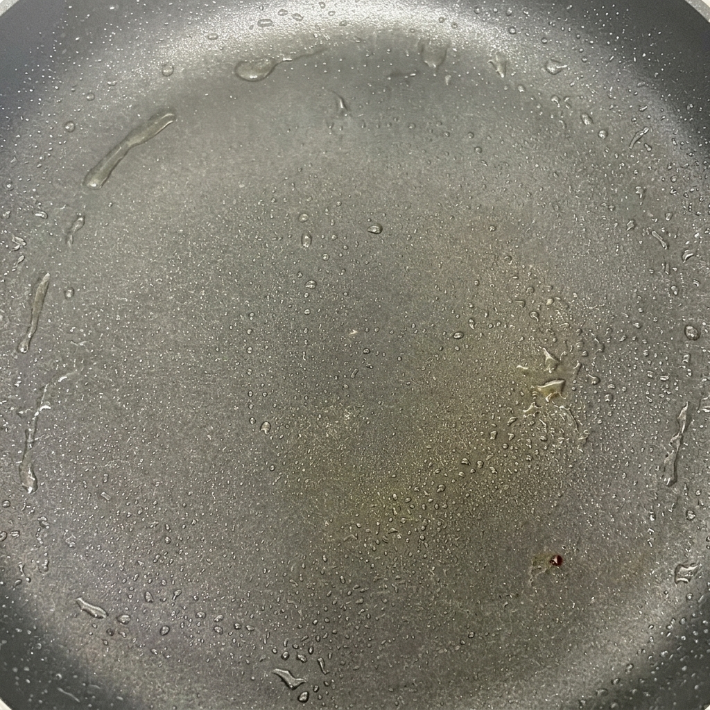 Pilzköpfe brutzeln in einer heißen Pfanne mit Öl und beginnen leicht zu bräunen.