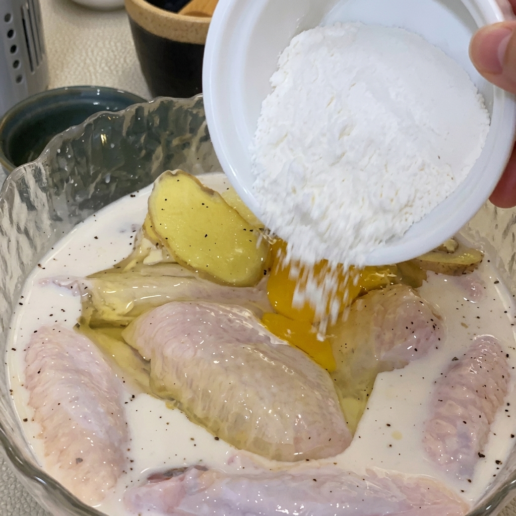 Eine Hand mischt Ei und Mehl in der Hähnchenschüssel zu einem Teig.