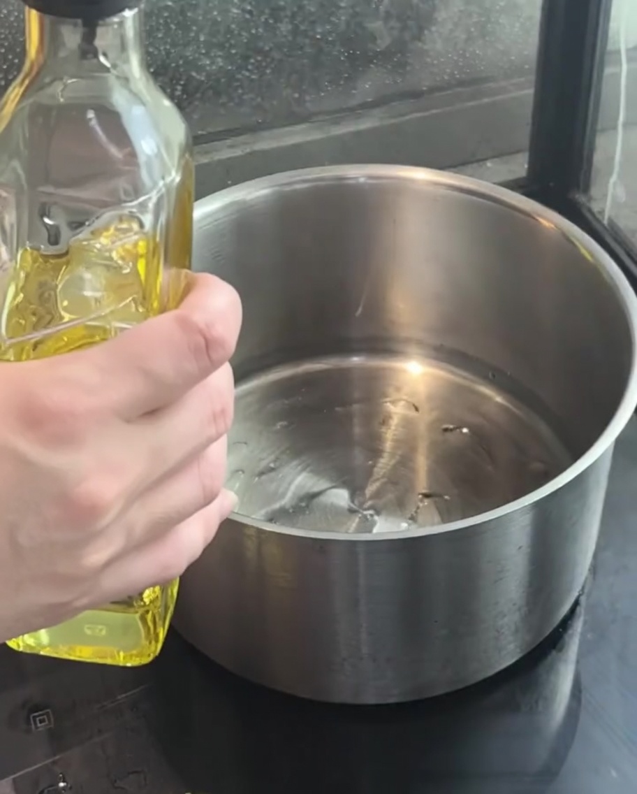 Gehackte rote Zwiebeln in heißem Öl in einem Topf.