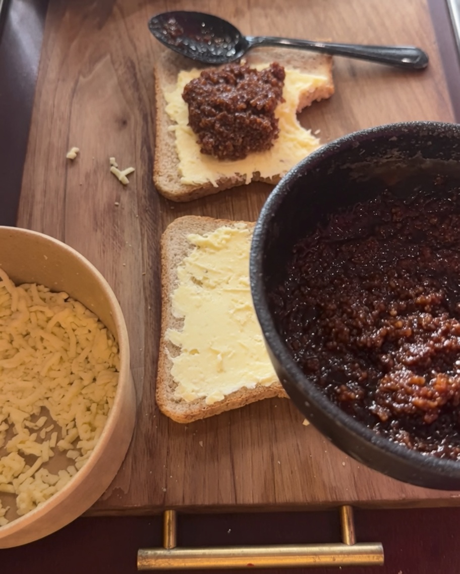 Eine großzügige Portion Hackfleischsauce wird auf den Käse gegeben.