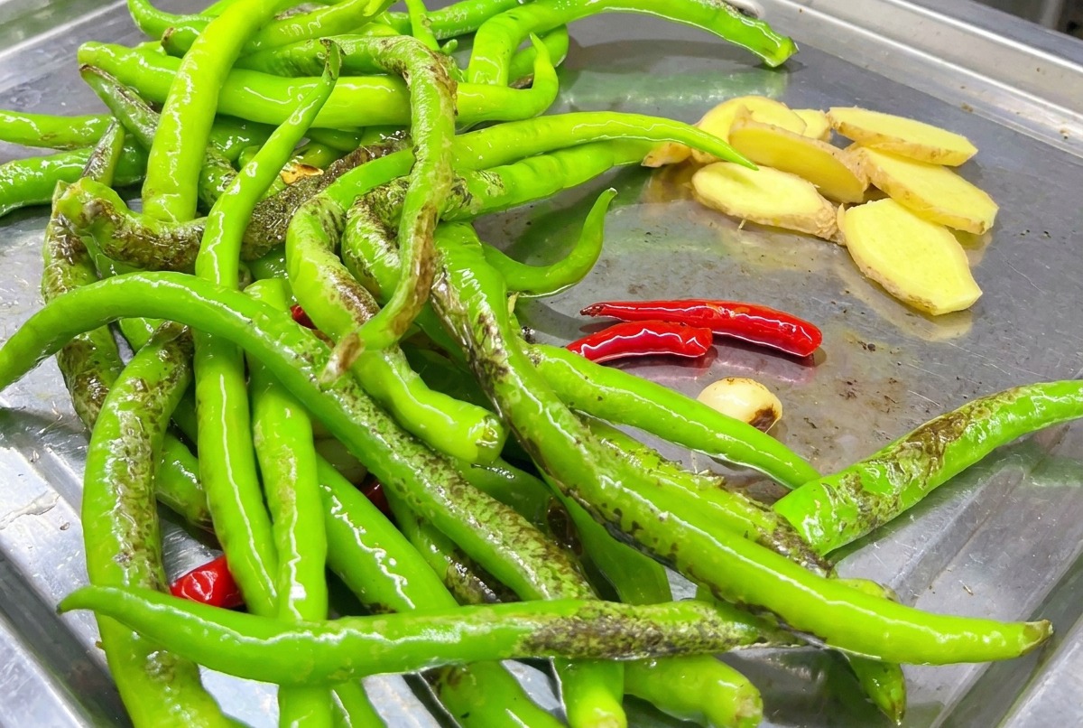 Ingwerscheiben, die zusammen mit den Chilischoten auf der Grillplatte angebraten werden.