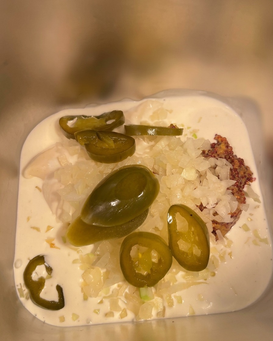 Ketchup wird in den Metallbehälter mit den übrigen Zutaten gegossen.