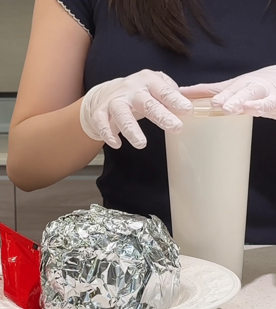 Ein frisch gebratenes Spiegelei wird auf den Stapel aus Speck und saftigem Patty gelegt.