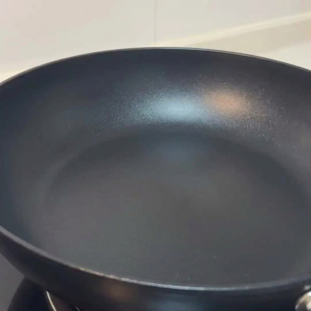 Geschnittene Pilze braten in einer Pfanne und werden mit Salz und schwarzem Pfeffer gewürzt.
