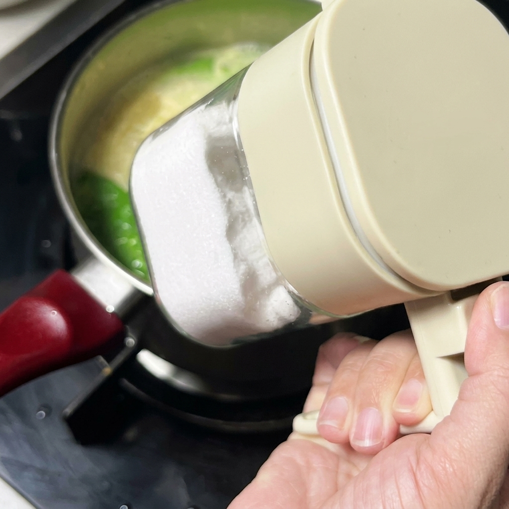 Salz wird aus einem Behälter in die Suppe gegeben.