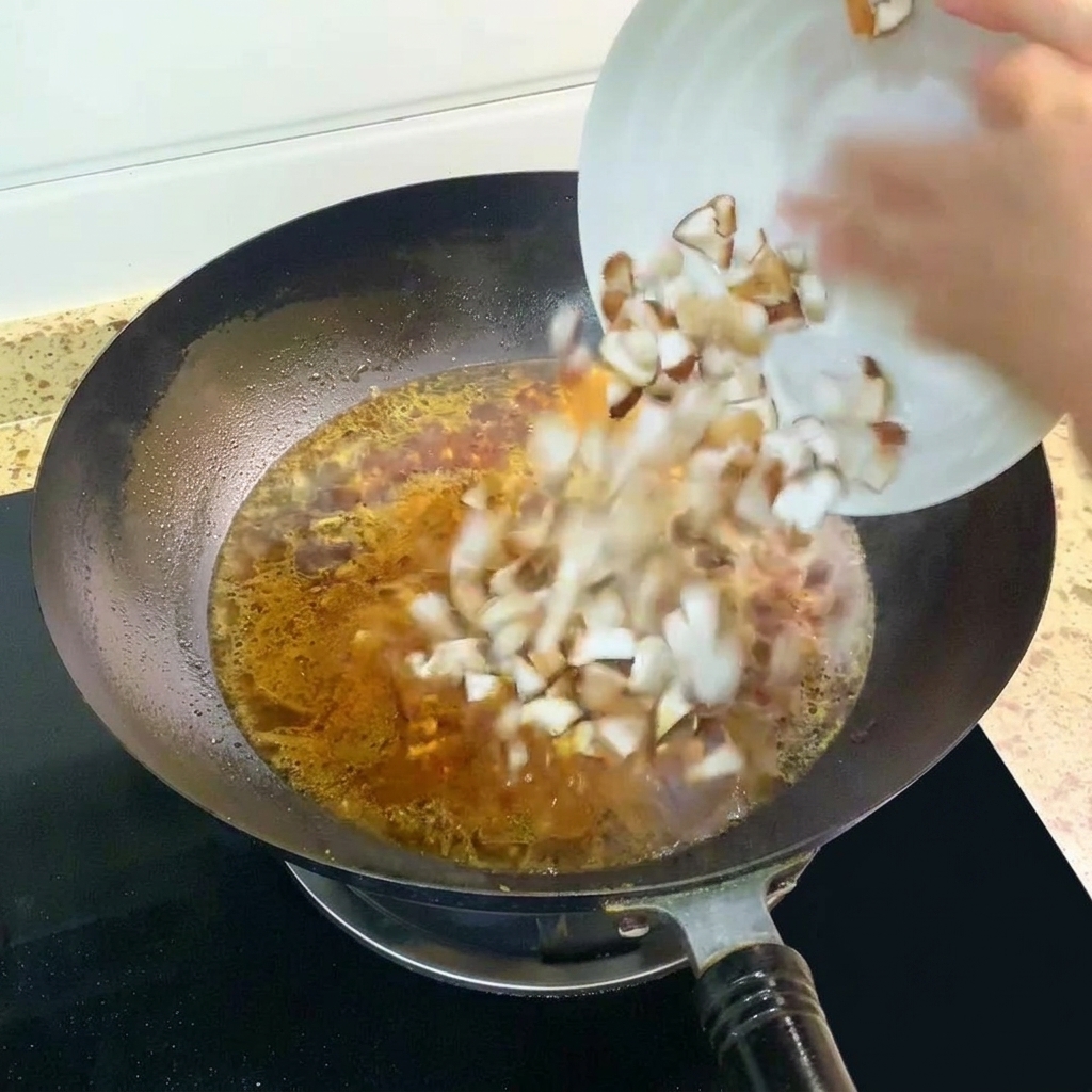 Gewürfelte Shiitake-Pilze werden in die kochende Suppe gegeben.