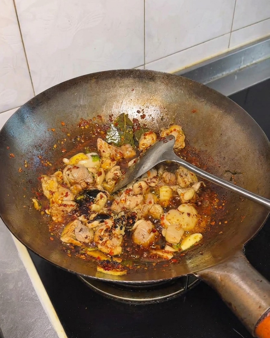 Sojasauce und weitere Gewürze werden in den Wok gegeben.