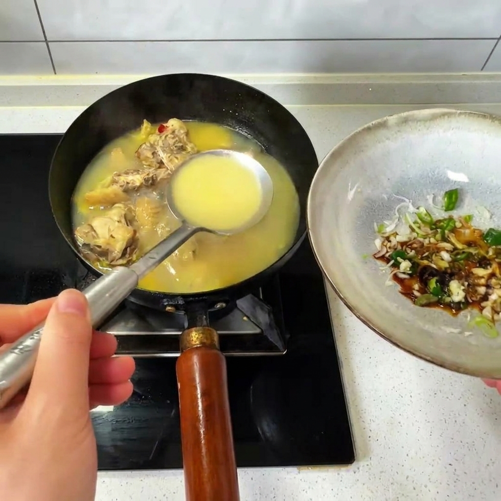 Eine Schöpfkelle mit heißer Hühnerbrühe aus einem Wok wird in eine Schale mit Gewürzen gegossen.
