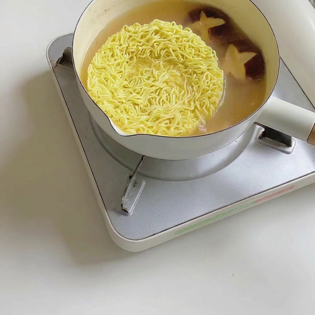 Frische Pak Choi Blätter werden in den Ramen-Topf gegeben.