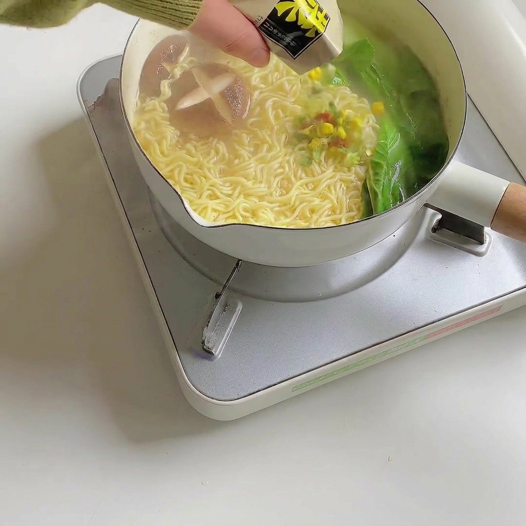 Ramen-Garnitur wird über die fertige Nudelsuppe gestreut.