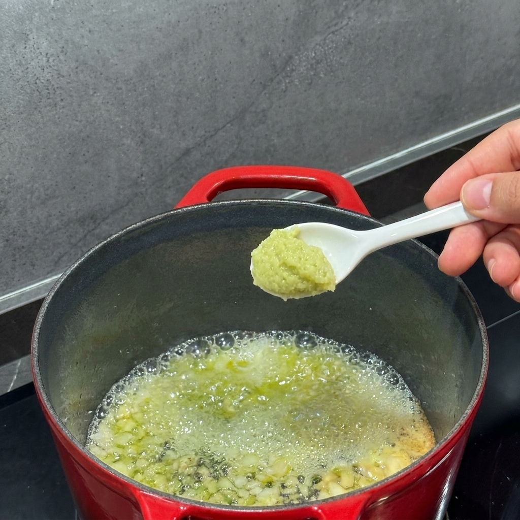 Mehl wird mit einem Schneebesen in die geschmolzene Butter im Topf eingerührt.