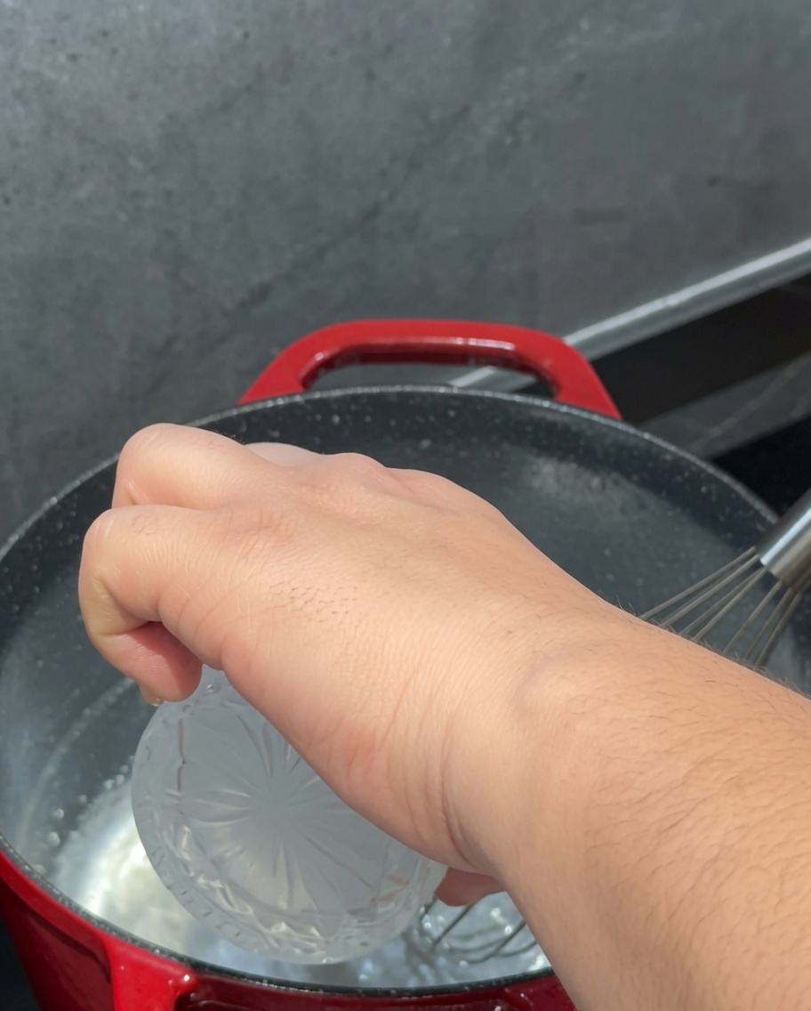 Milch wird langsam in den Topf gegossen und mit der Mehlschwitze verrührt.