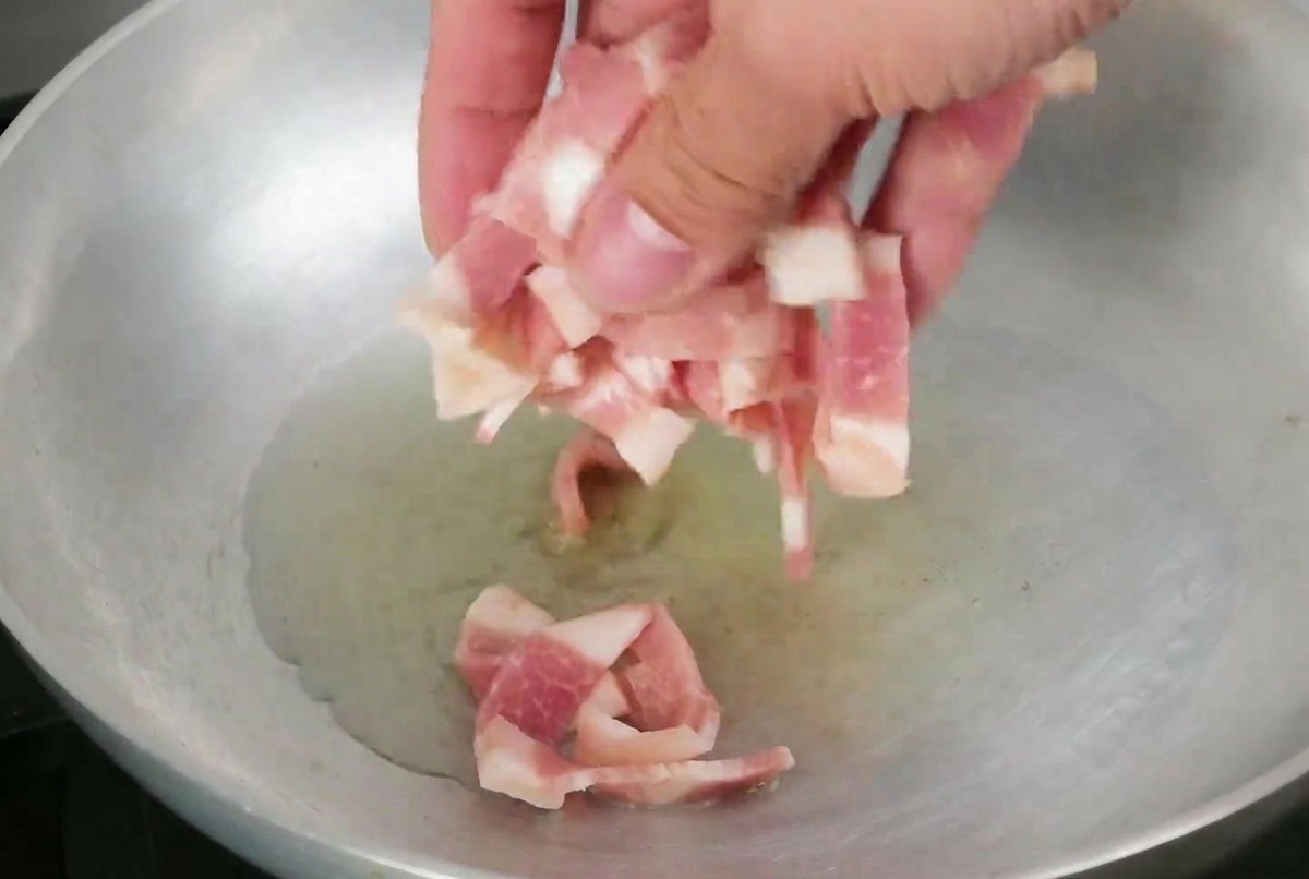 Speckstreifen in einer Pfanne mit Olivenöl.