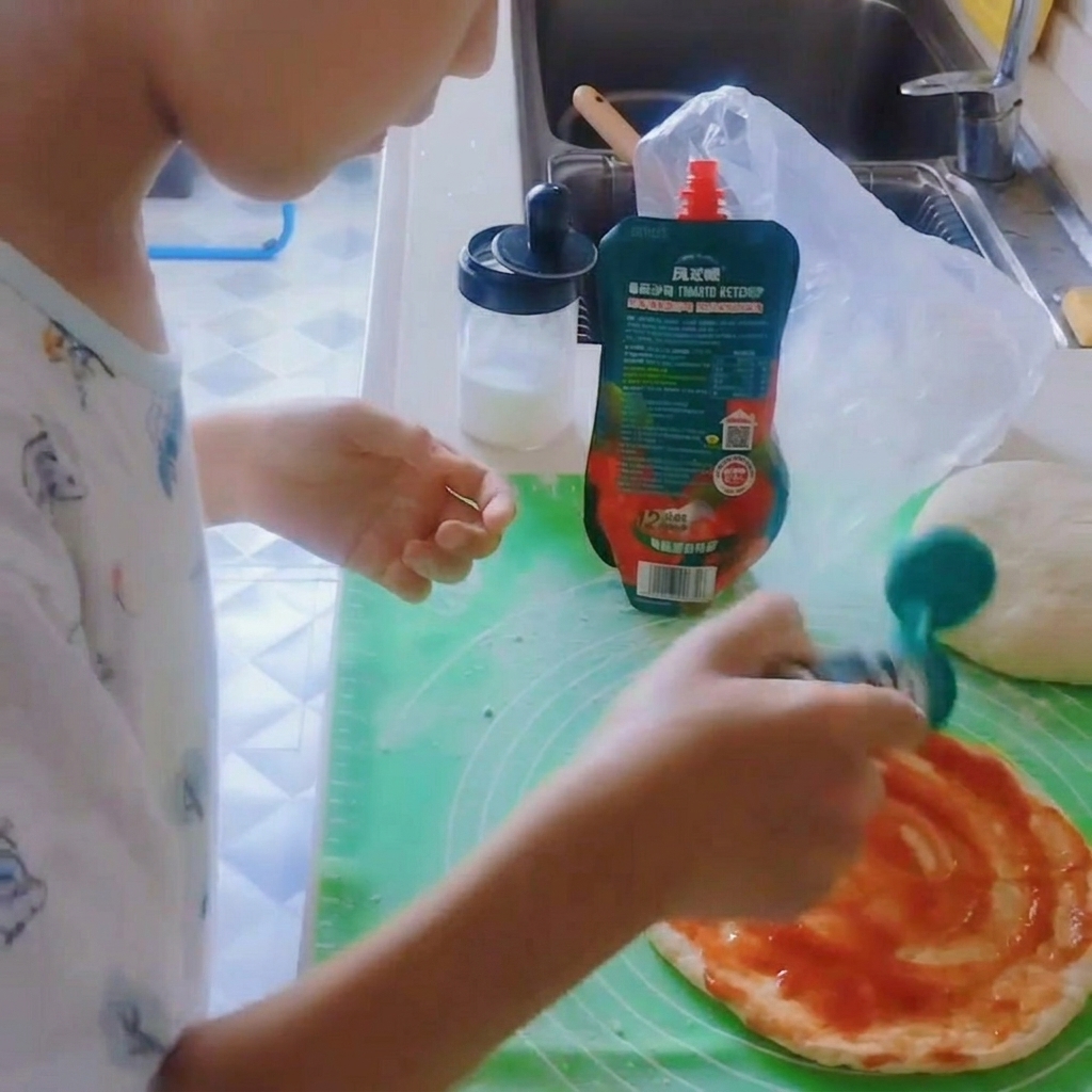 Schwarzer Pfeffer wird auf die belegte Pizzabasis gestreut.