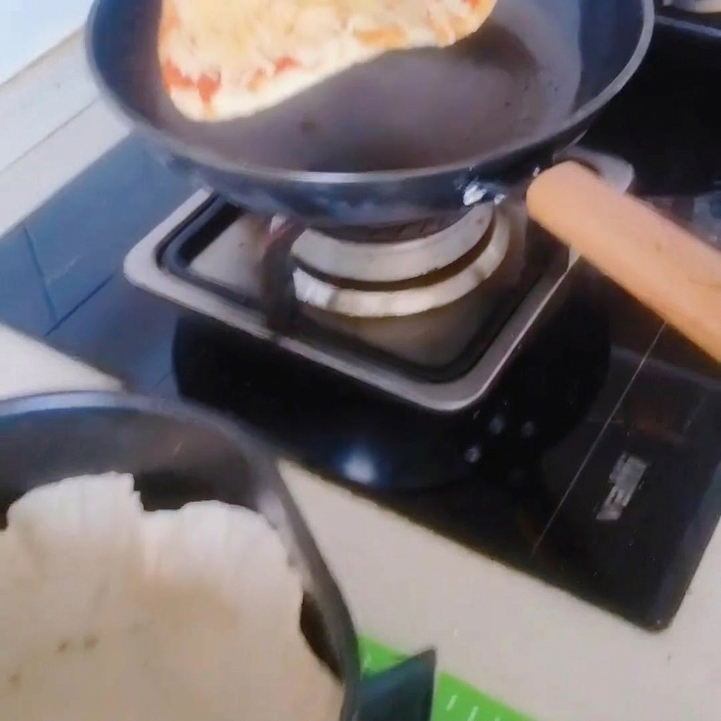 Die Pizza wird vorsichtig in einen mit Backpapier ausgelegten Heißluftfritteusen-Korb geschoben.