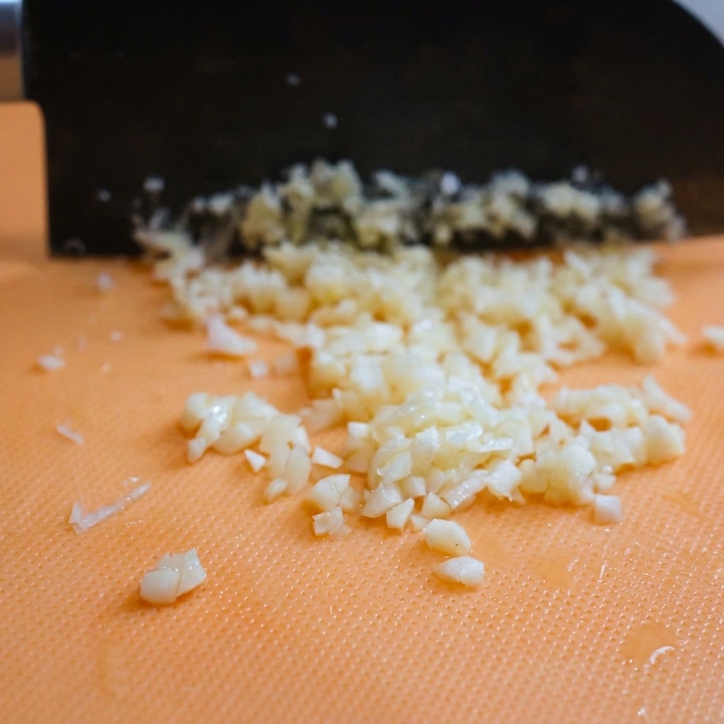 Haufen von frisch geriebenem Parmesan auf einem Schneidebrett.