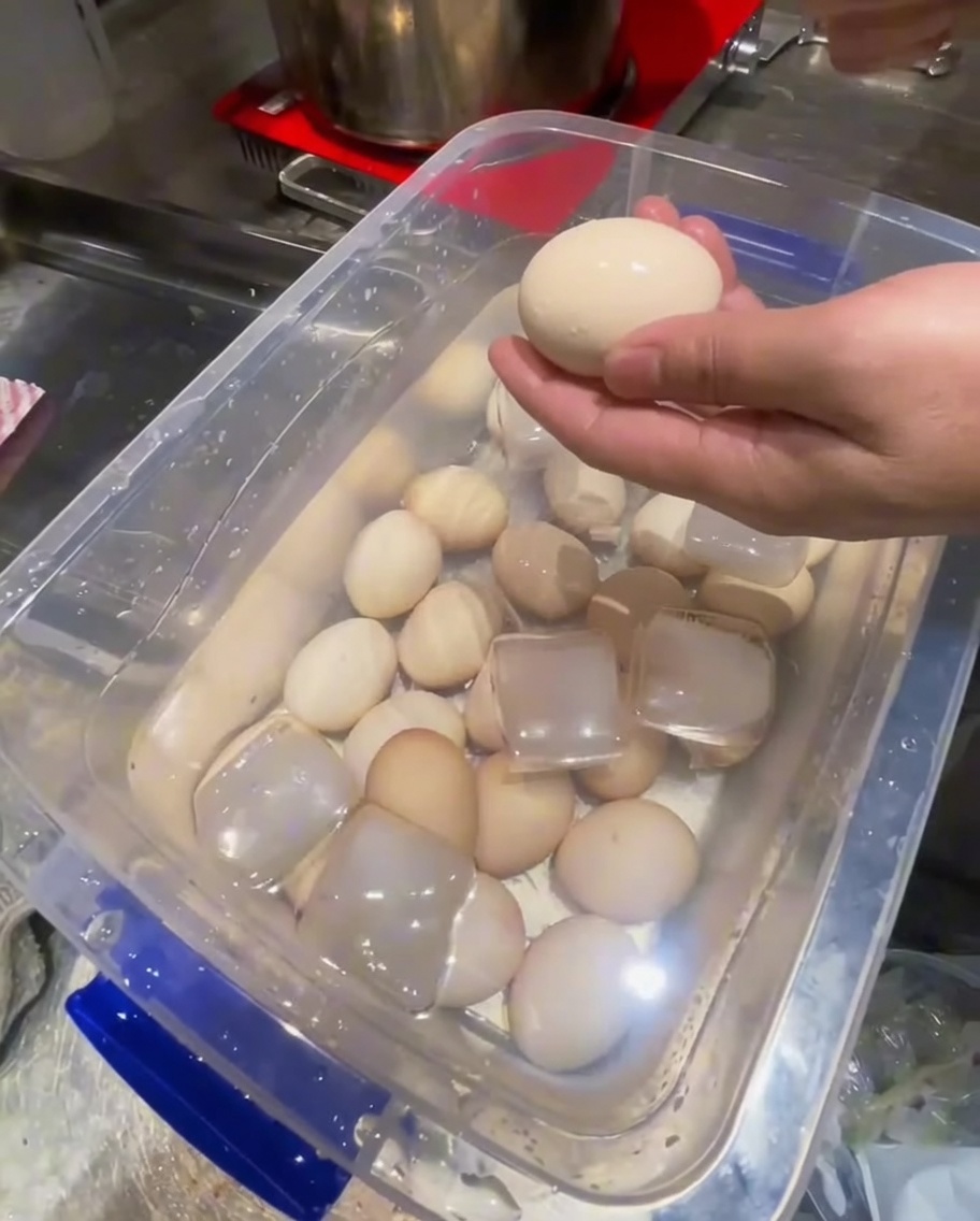 Entfernen der Schalen von abgekühlten Eiern mit einem Metalllöffel.