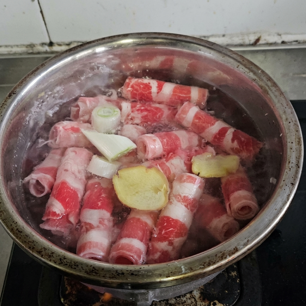 Rindfleischröllchen kochen in einem Topf mit Gewürzen und Kochwein.