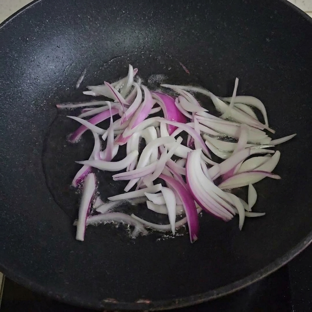 Zwiebelstreifen braten in einer heißen, geölten Pfanne.