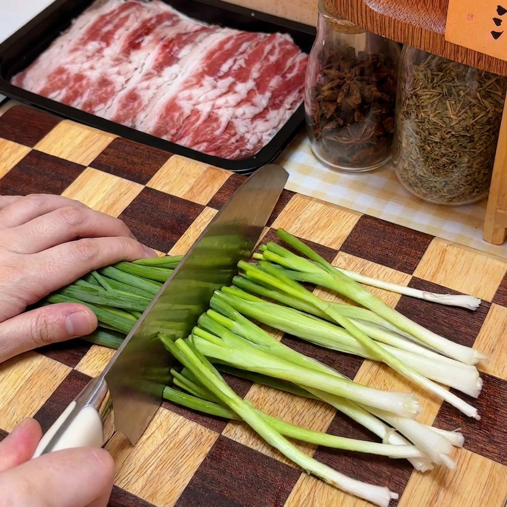 Fein gehackte Frühlingszwiebeln auf einem Holzbrett neben einer Rindfleisch-Packung.
