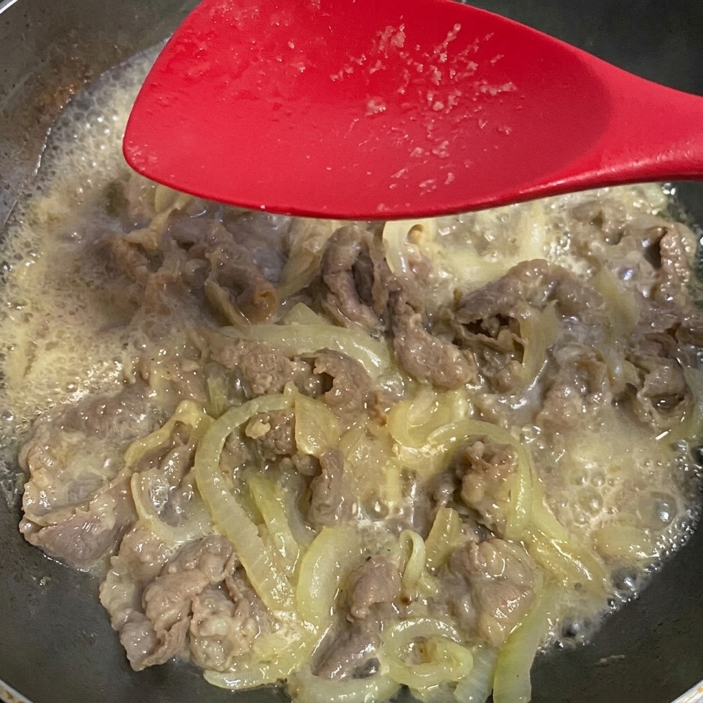 Sojasauce wird zur Rindfleisch-Zwiebel-Mischung hinzugefügt.