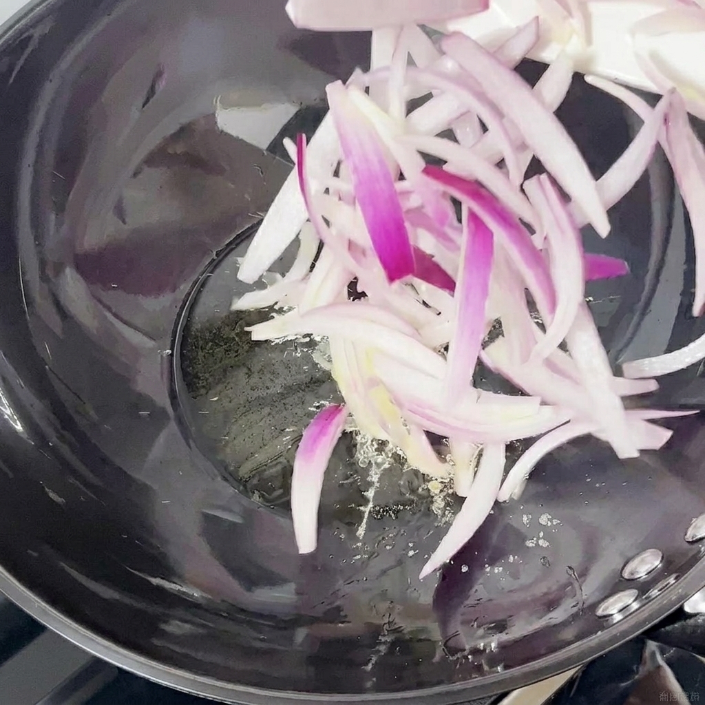 Rote Zwiebelstreifen werden in einem Wok angebraten.