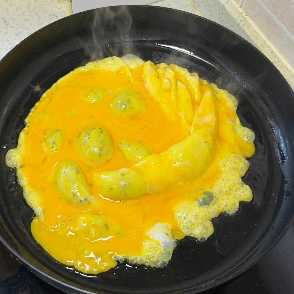 Eier werden mit einem Holzspatel sanft in einer Pfanne gerührt.