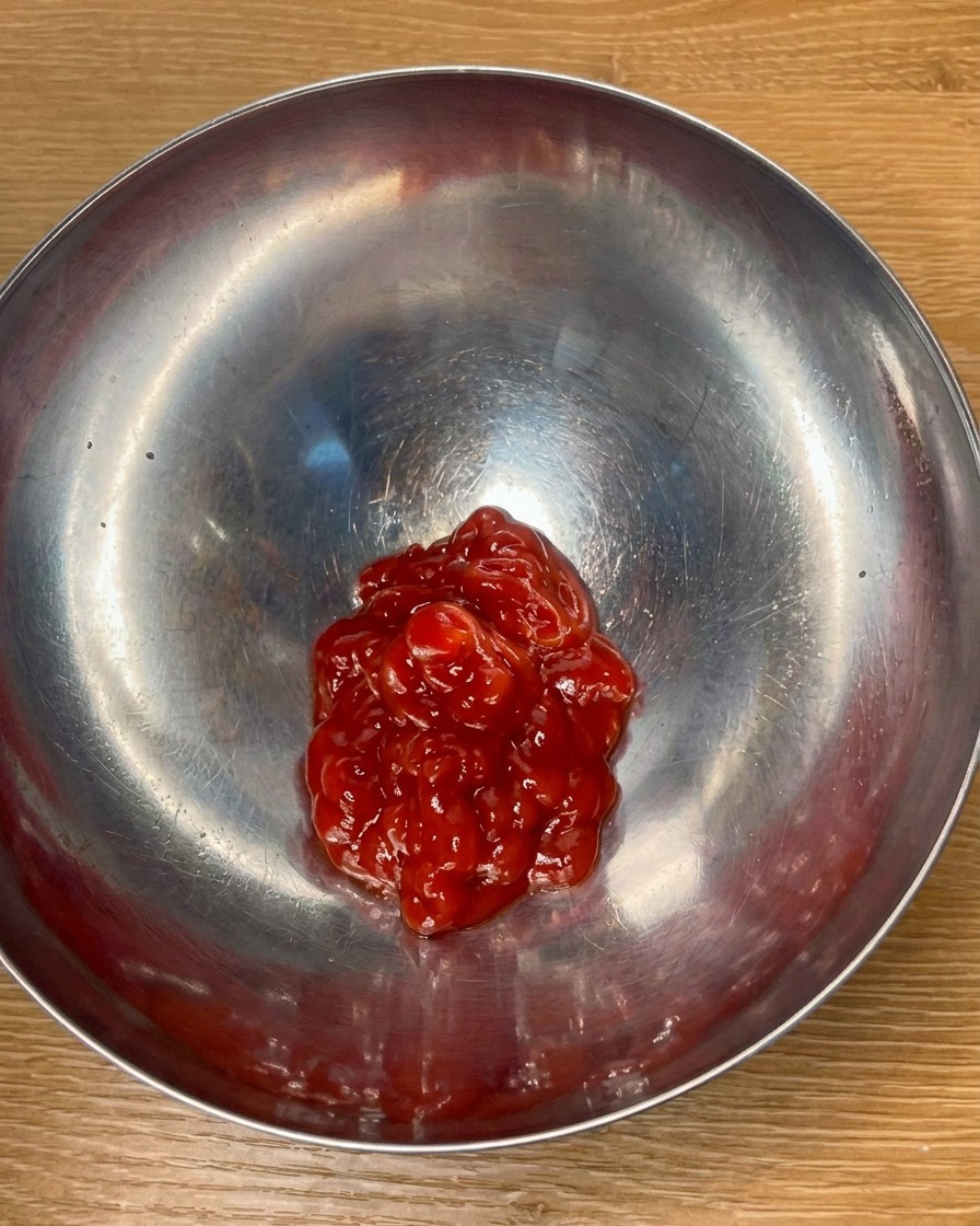 Tomatenketchup und Gewürze werden in einer Schüssel zu einer Sauce vermischt.