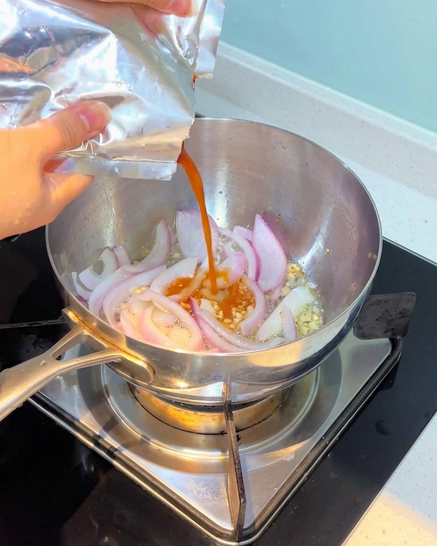 Kimchi wird in den Topf gegeben und mit Zwiebeln und Knoblauch vermischt.