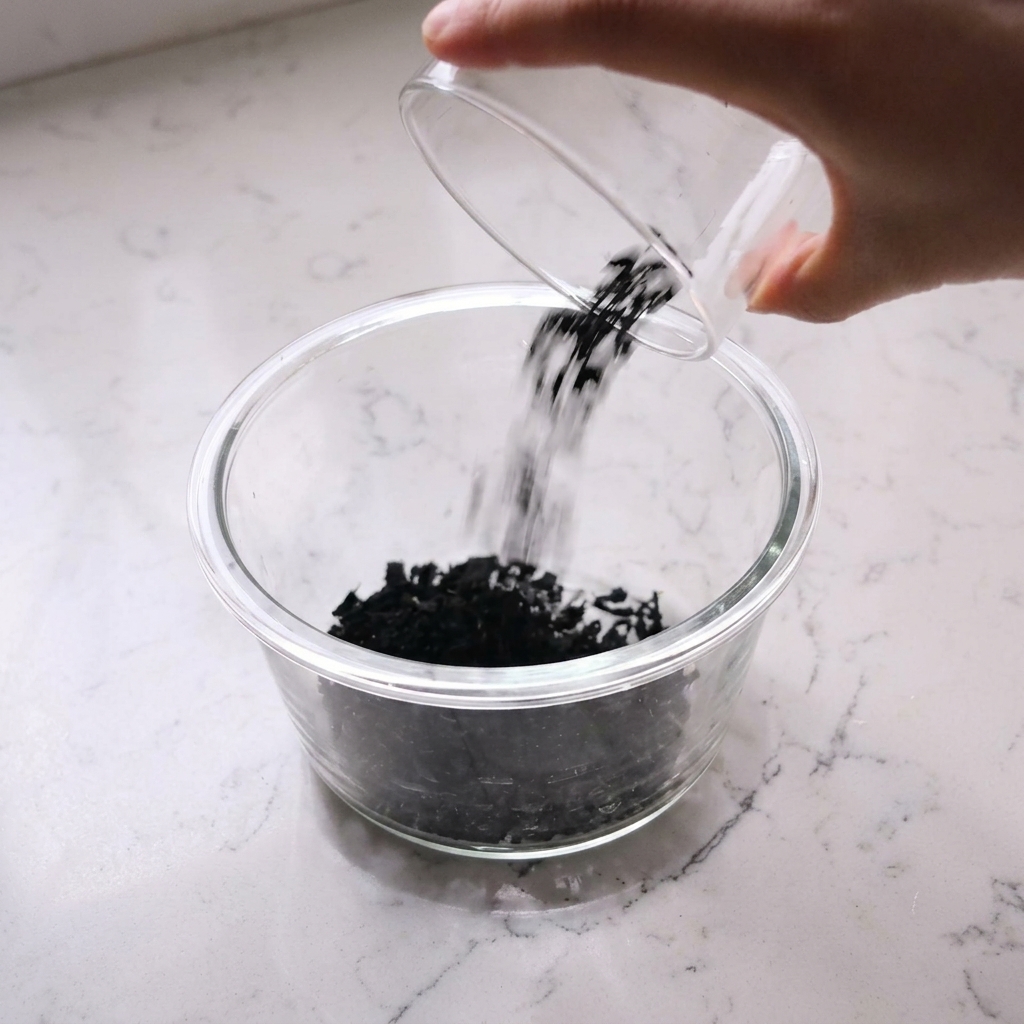 Getrocknete Wakame-Algen in einer mit Wasser gefüllten Glasschale.