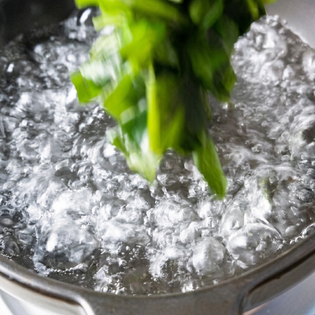 Wakame und Tofuwürfel werden in einen Topf mit kochendem Wasser gegeben.
