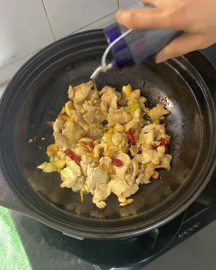 Sojasaucen und Austernsauce werden zur angebratenen Schweinefleischmischung gegeben.