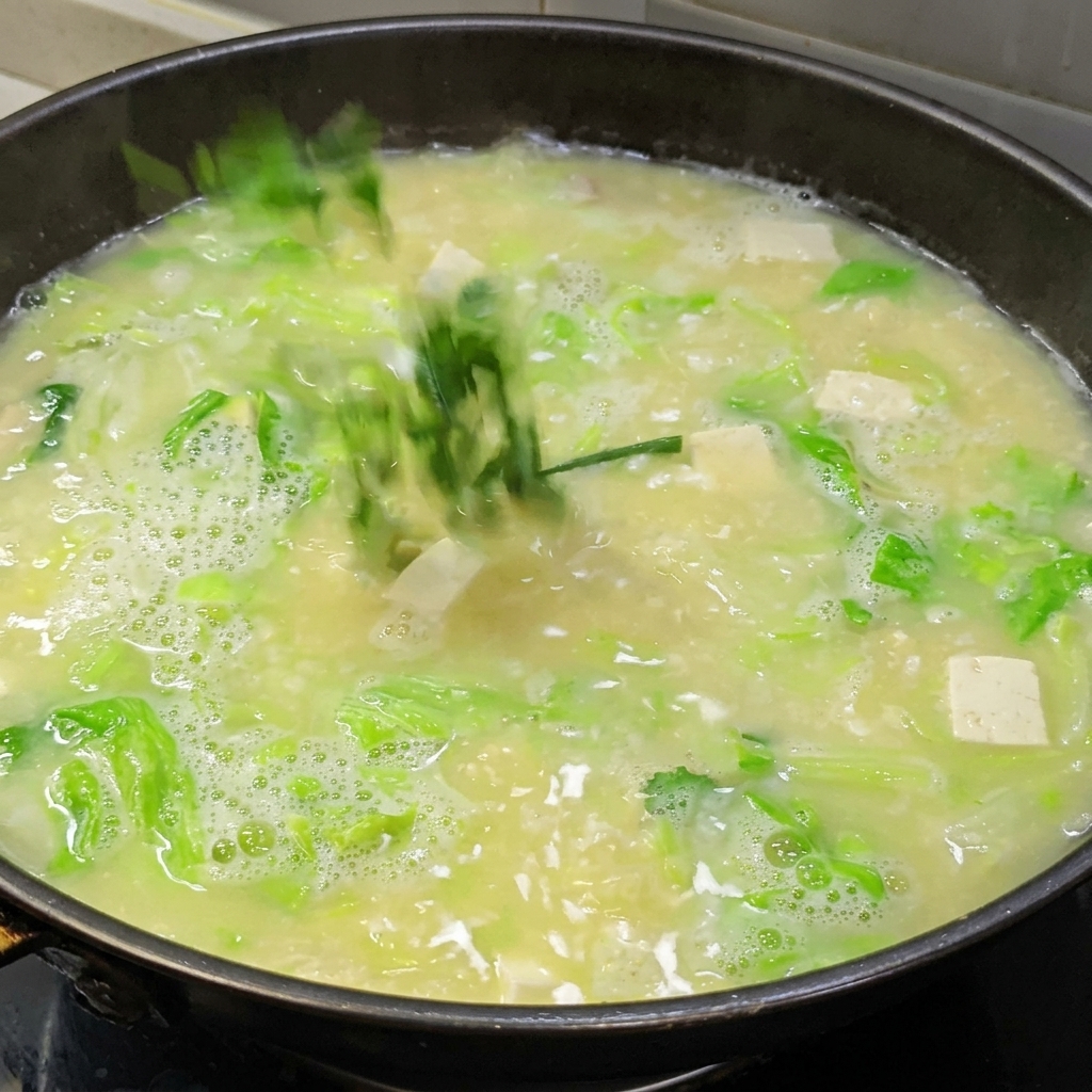 Stärkewasser wird in die köchelnde Suppe gegossen, um sie einzudicken.