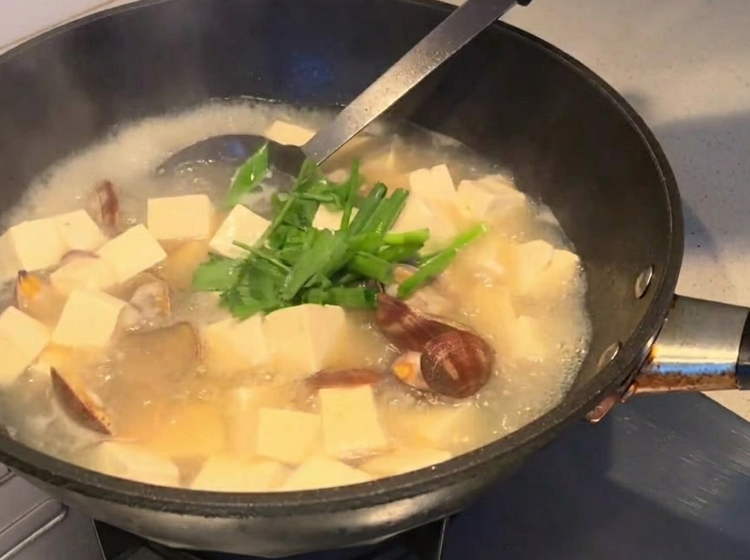 Frische Kräuter werden über die fertige Suppe gestreut.